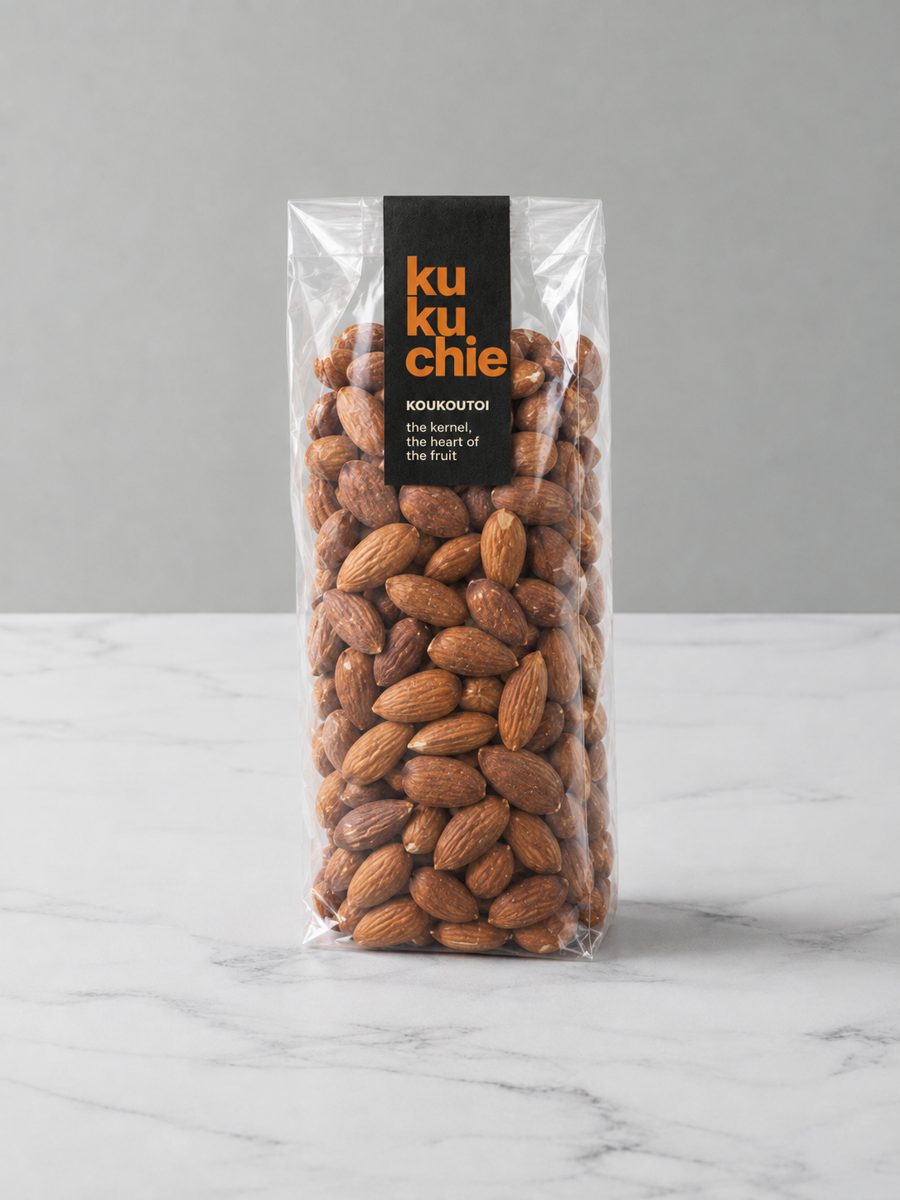 A clear bag of raw ku kuchie almonds with a black and orange label
